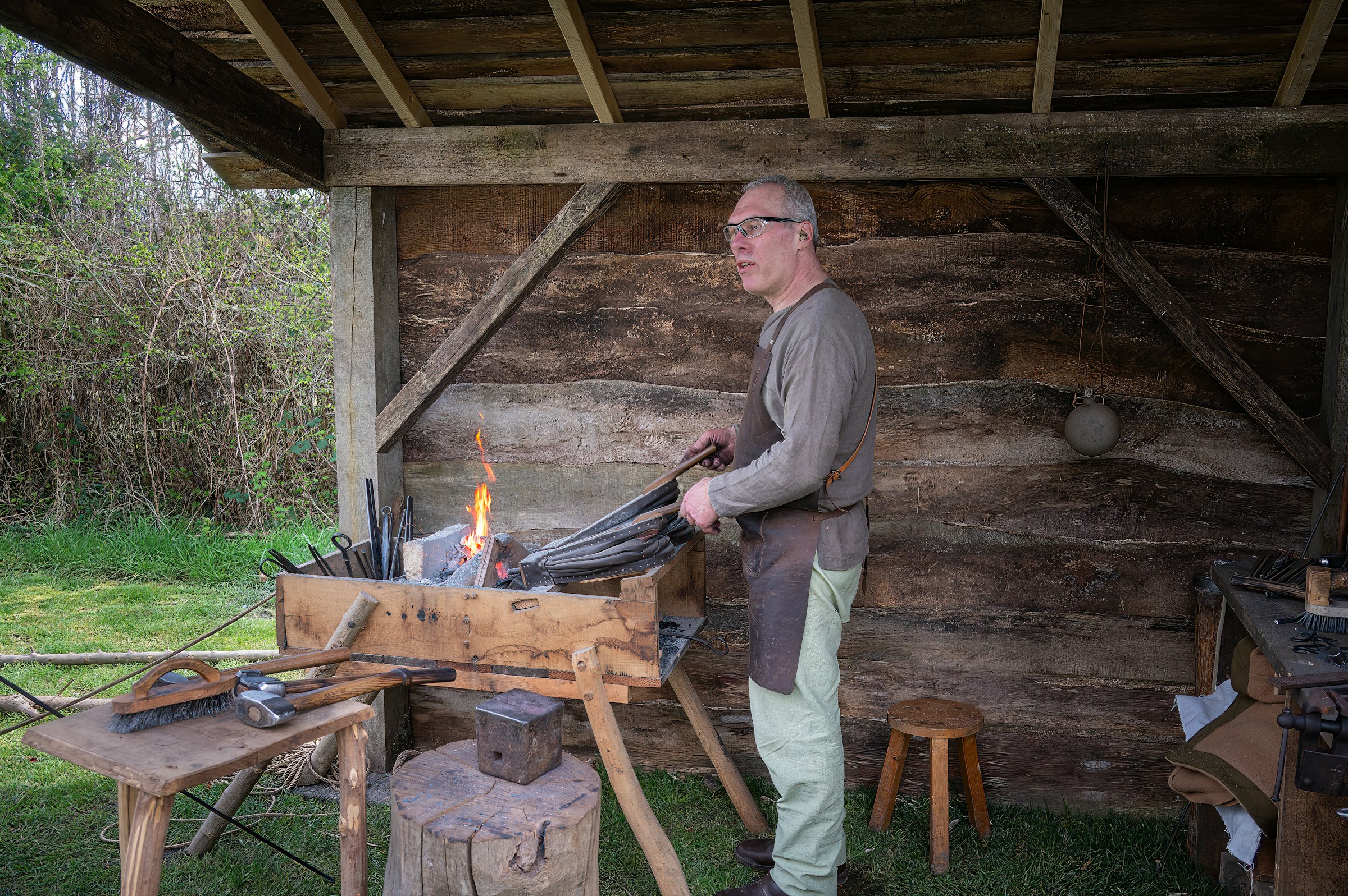 Blacksmith working at the forge with flames
